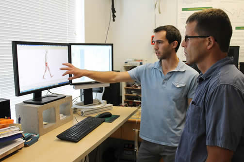 Student discussing image on monitor with his professor.