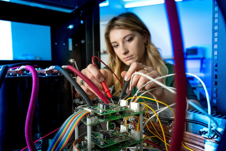 Student works on electronics in a lab.
