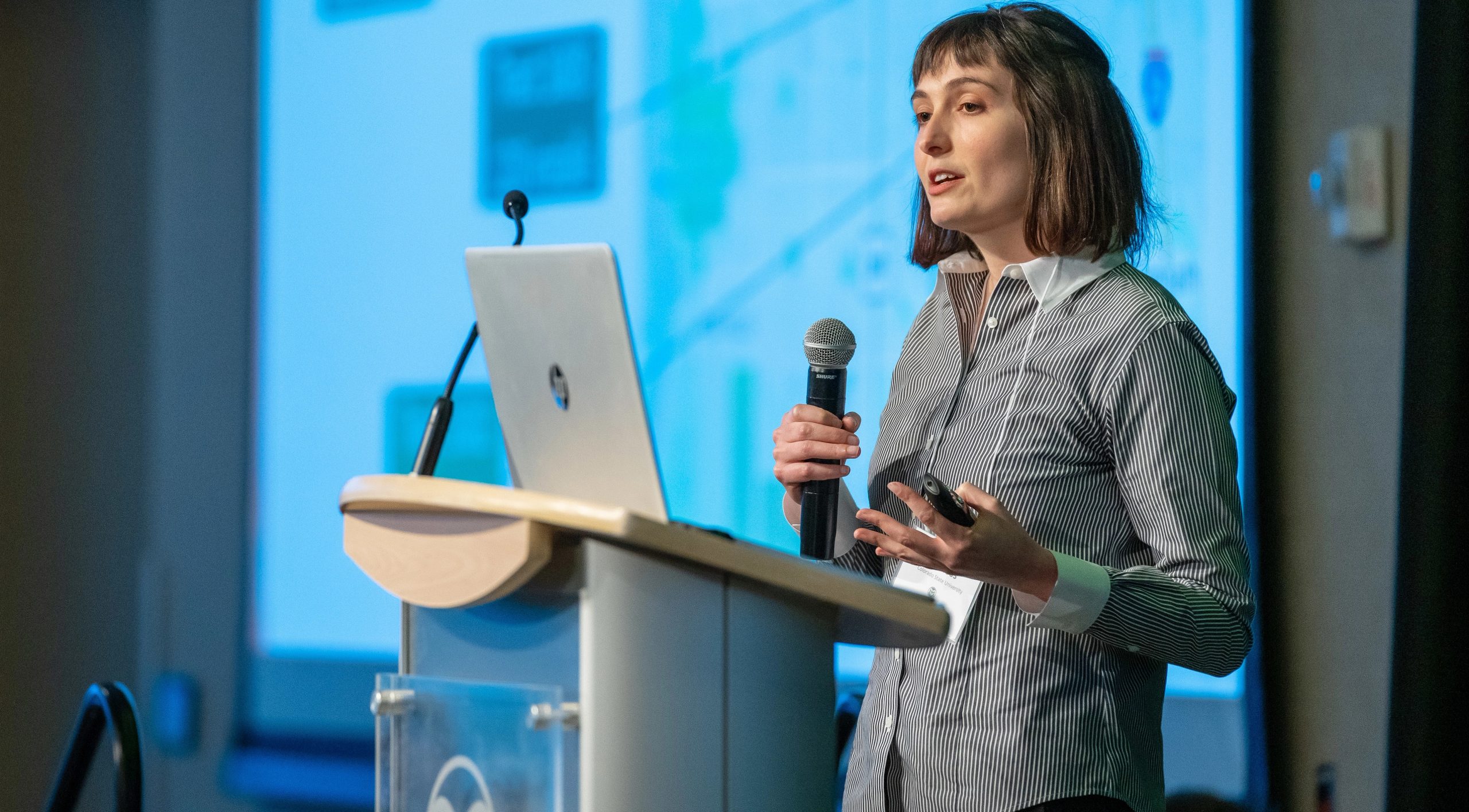 Student giving presentation from lectern with microphone.