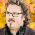 Portrait of Dr. David Florian Vetsch in front of a yellow background.