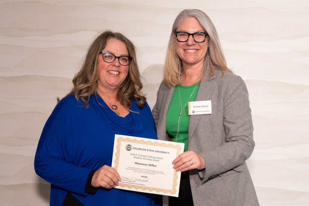 Michelle Stanley presenting Shannon Miller with award certificate.