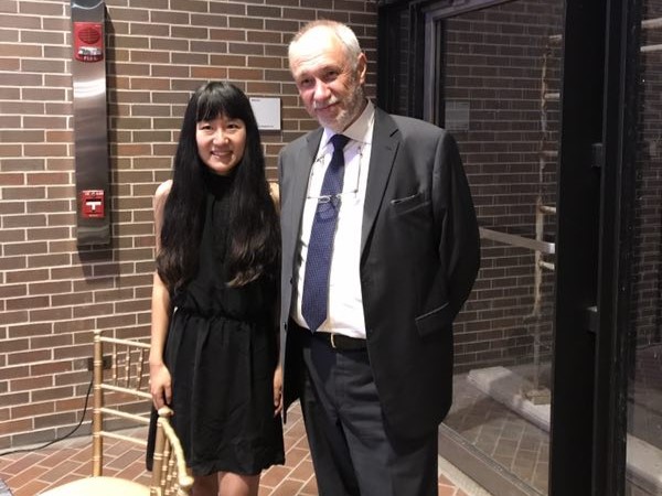 Woman in black dress standing by man in suit.