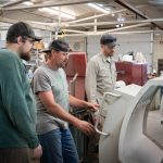 Men inspect machinery.