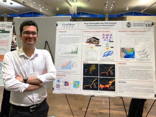 Man in white shirt stands by poster.