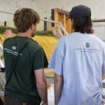 Two students discuss hydraulic structure with the back of the shirts reading "Hydraulics Laboratory".