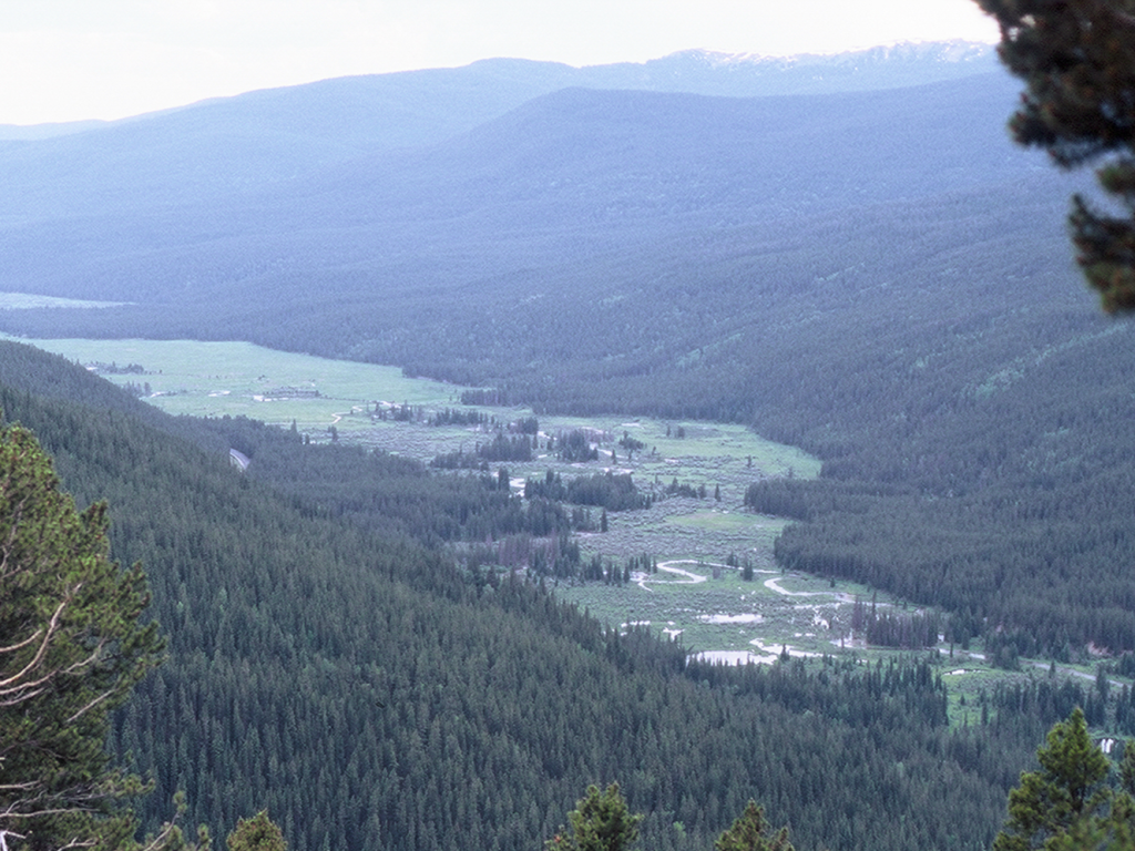 Aerial photo of winding river in mountain valley.