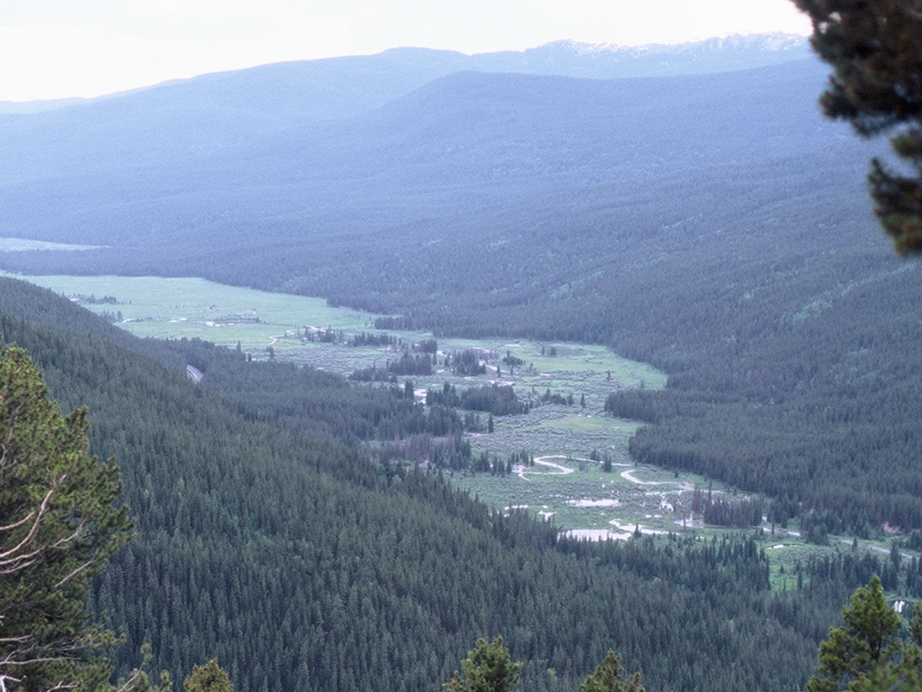Aerial photo of winding river in mountain valley.