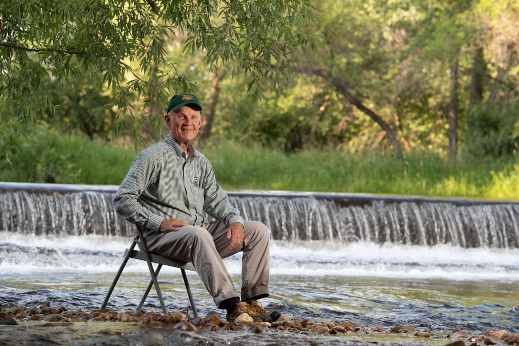 Man sitting in chair in river.