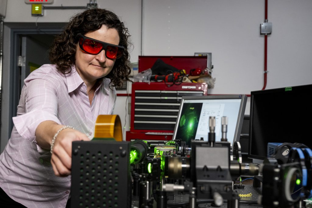 Student in lab wearing safety glasses working on project