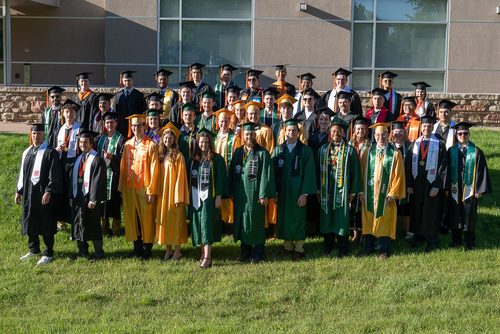 Large group of students in regalia pose for graduation