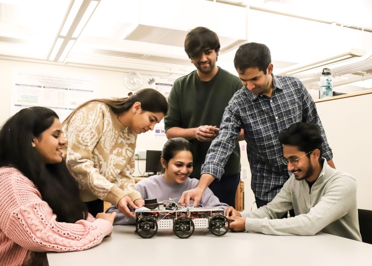 Six students pose with student car project