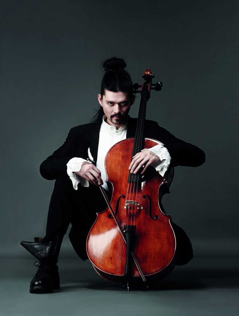 dramatic photo of man holding cello