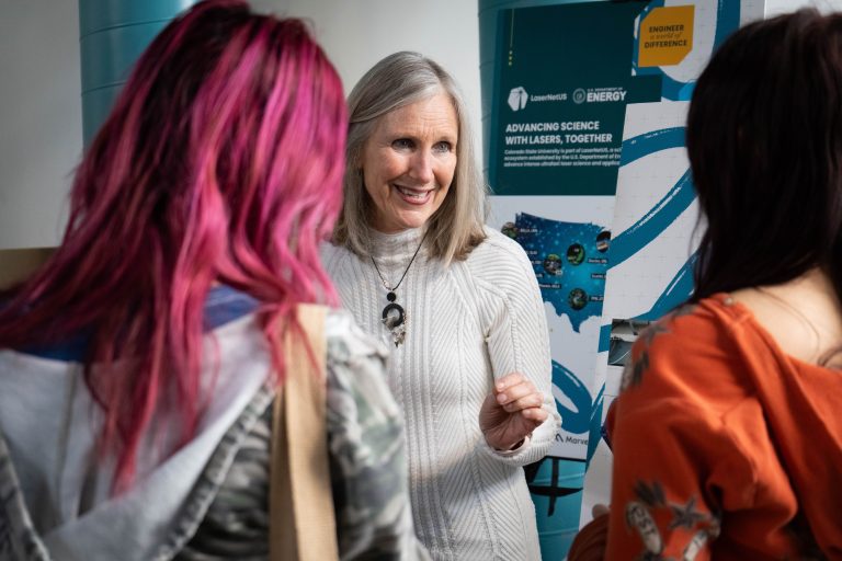 Carmen Menoni talks to two female students