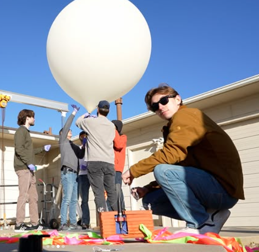 Team of three male students launch balloon