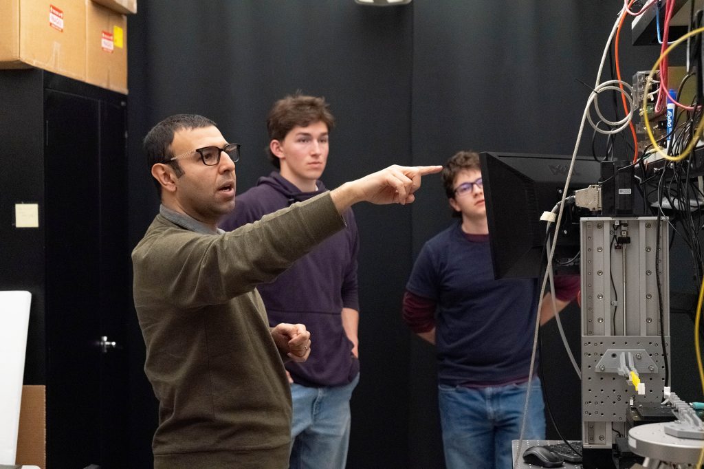 Mahdi Nikdast points to computer monitor as two students watch