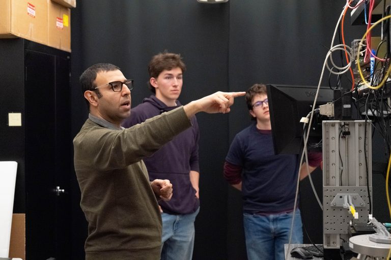 Mahdi Nikdast points to computer monitor as two students watch