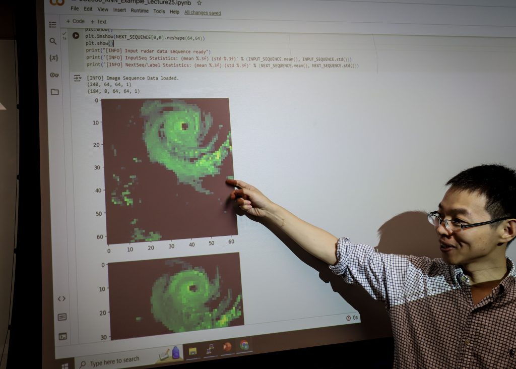 Man points at weather satellite data on a screen