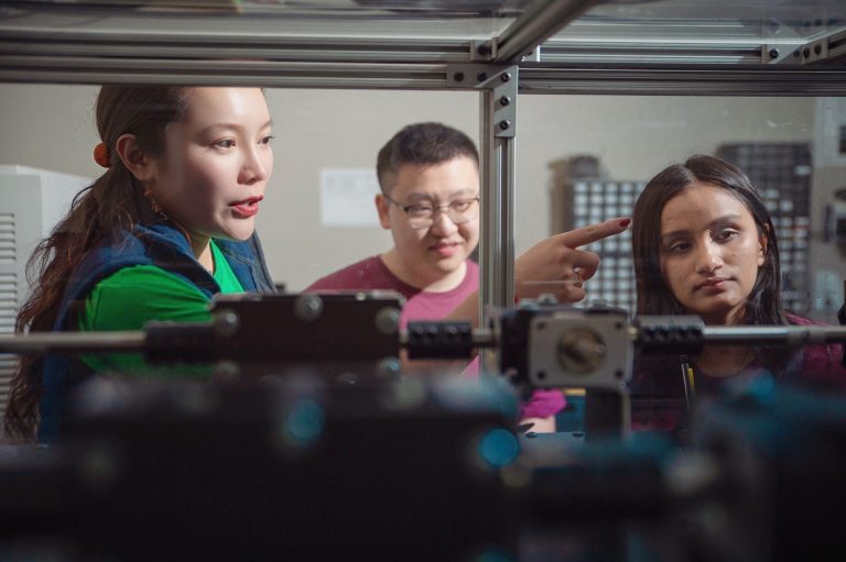 two women, one man work on power system
