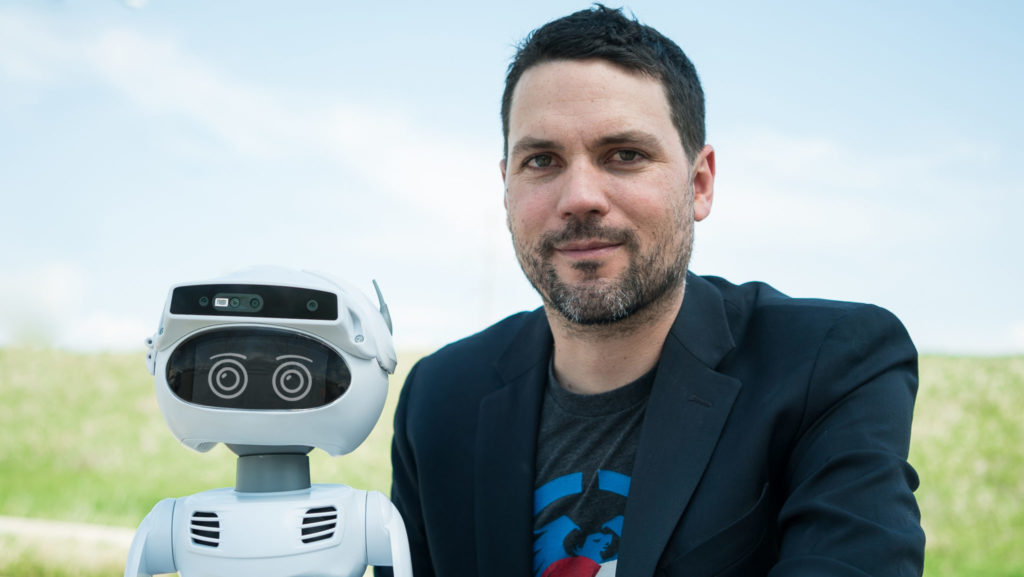 Man stands next to robot