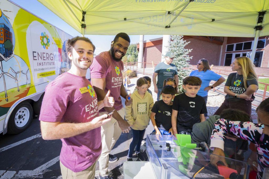 Josh Rodriguez, and Joshua Oluwatumise at the 2024 Children's Water Festival. They are preforming a demonstration about dams and hydraulic power for a group of elementary students.