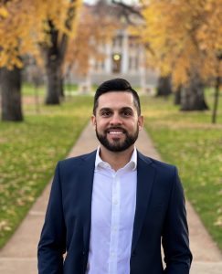 A professional photograph of Dr. Andre Pigatto posing in the CSU oval, in front of the administration building.