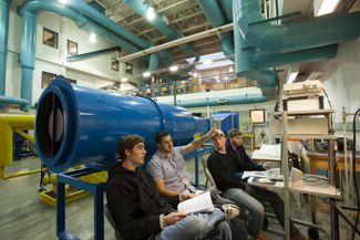 Students studying by the wind tunnel