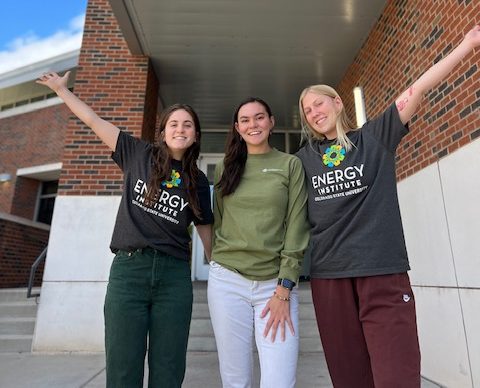 Three female students posing in front of the Powerhouse.