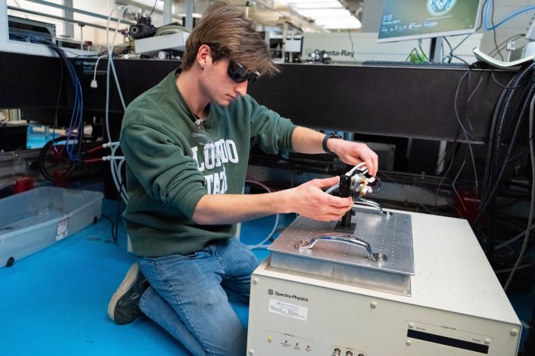A student installing a laser cooling device.