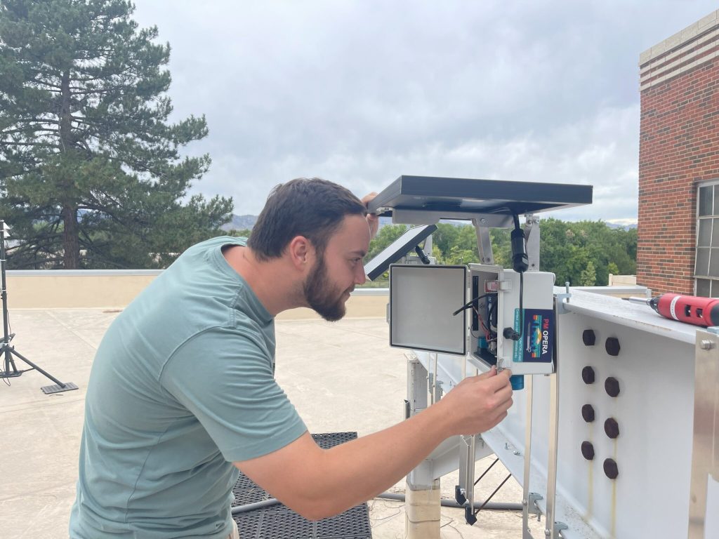 Student studies air quality monitor.