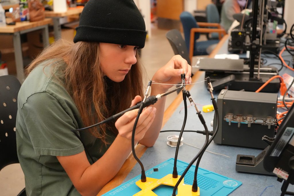 Student soldering a wire