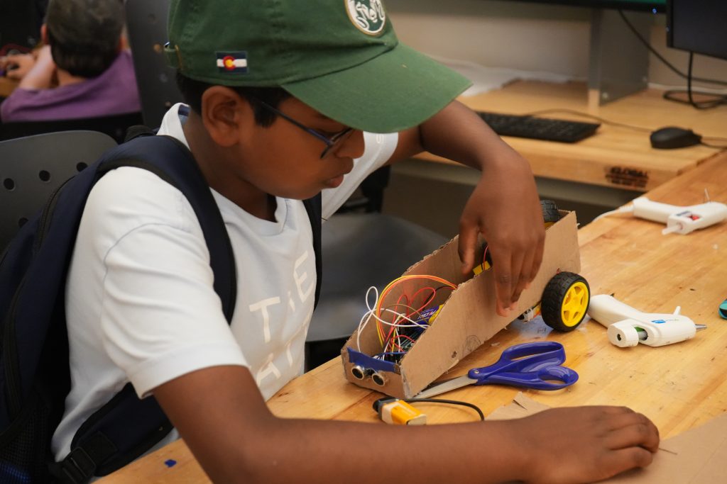 Student wiring a model car.
