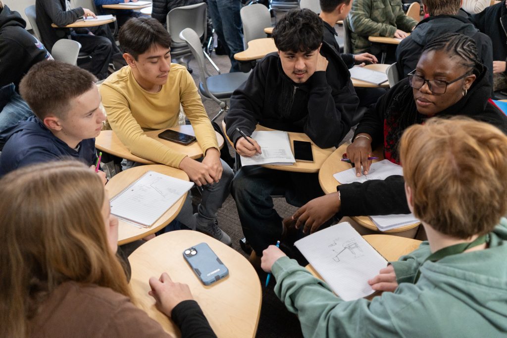 A group of students sitting in desks in a circle
