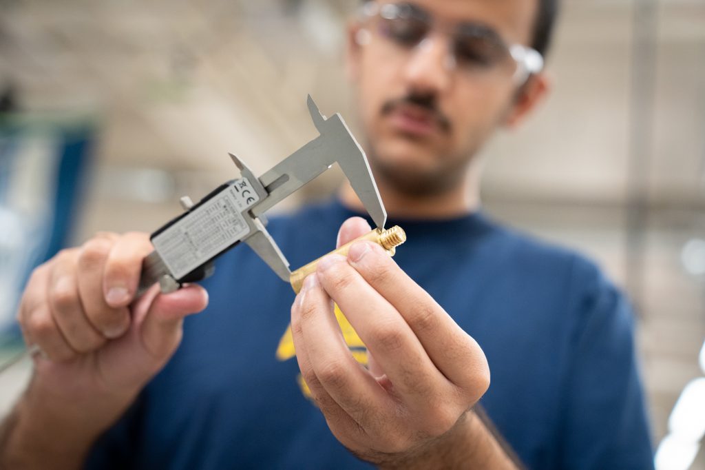 Student making a measurement with calipers