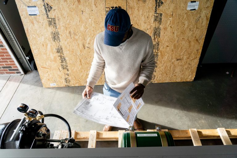 A systems engineering graduate student puts together test platforms at Colorado State University's Powerhouse, December 17, 2020.