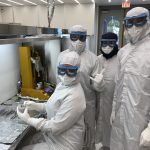 Four NASA scientists dressed in white lab clothes