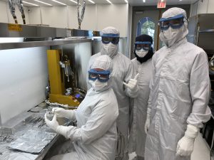 Four NASA scientists dressed in white lab clothes