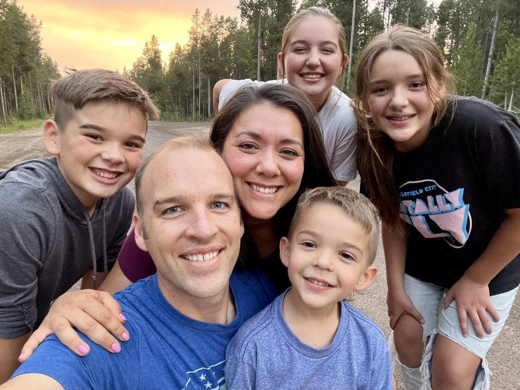 Danny Call and his family, smiling in front of a sunset.