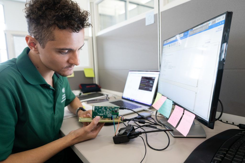 Student working on a circuit board attached to a computer
