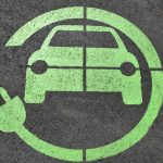 Green icon with a car and a plug wrapping around it printed on the ground. Indicates this is where an electric vehicle can be charged.