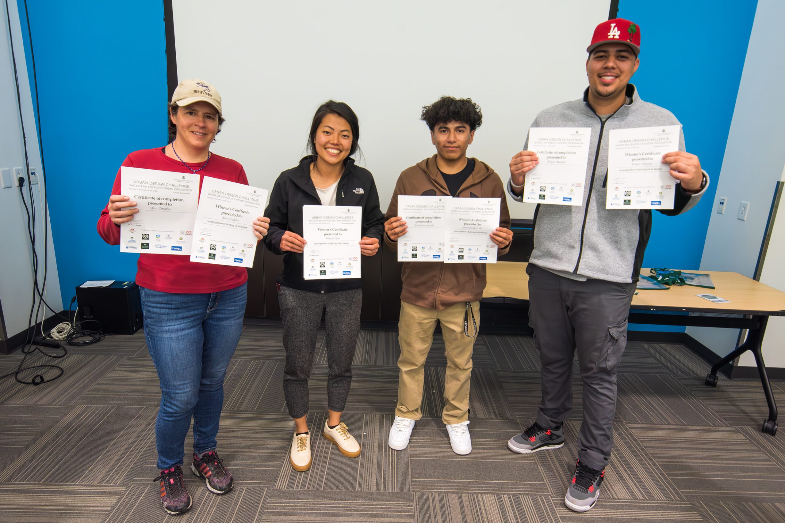 Four people show their awards after the Urban Design Challenge.
