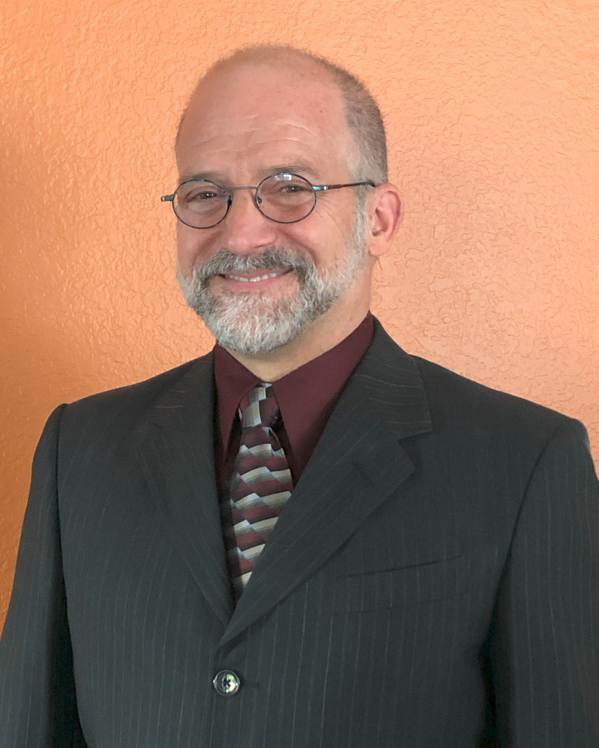 A man in glasses and a suit.