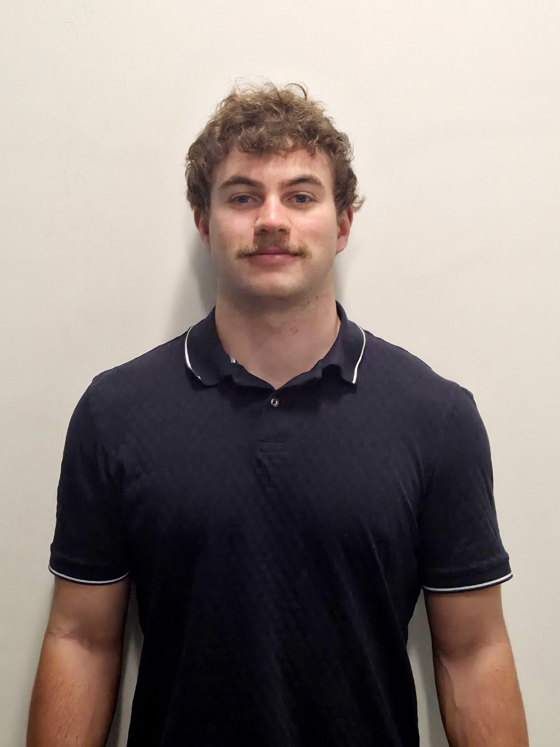 A man in front of a blank wall.