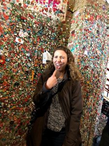 CSU student Sami Fischer next to a gum wall