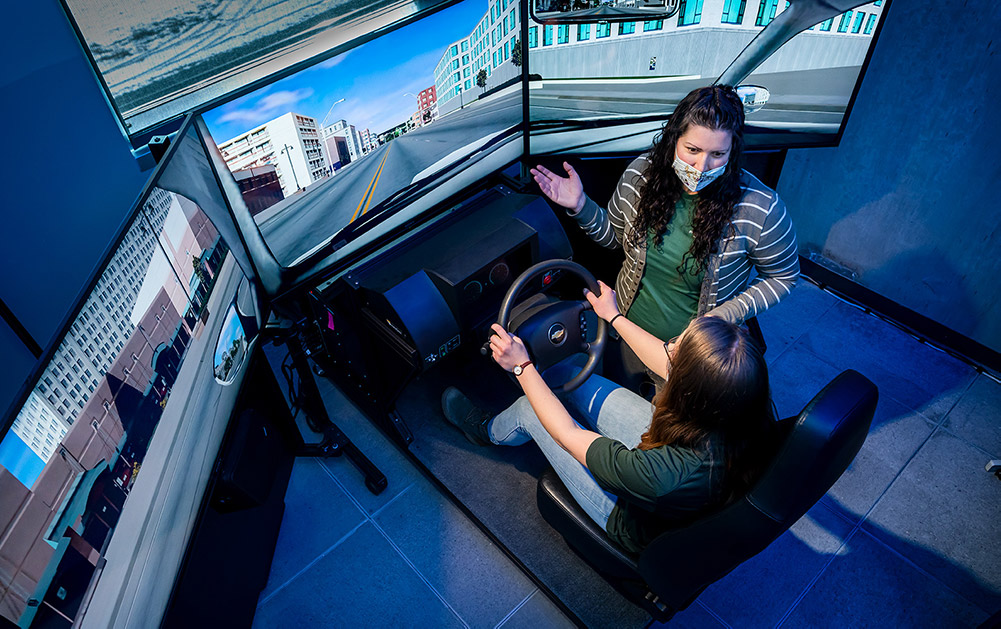 Erika Miller, Assistant Professor in the Systems Engineering department in the Walter Scott, Jr. College of Engineering works with test student on drive simulator, December 17, 2020.