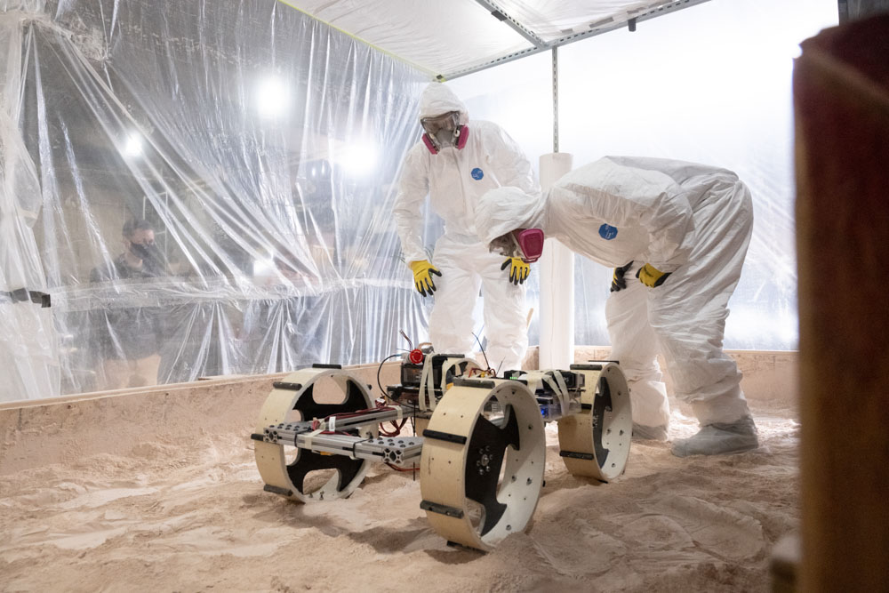 The Senior Design Team “NASA Robotic Mining Competition Team” consisting of Mechanical Engineering students Carissa Vos, Corbyn Berg, Hunter Pearson, Noah Kolda, Zelin Yang, Mike Irlbeck, Logan Litchfield and Electrical and Computer Engineering majors Dylan Clem and Ryan Busue, work on their chassis in a test pit. December 12, 2021