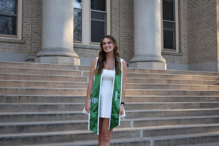Olivia Brown, the recipient of the 2024 CEC Silver Medal, stands on the Administration Building steps.
