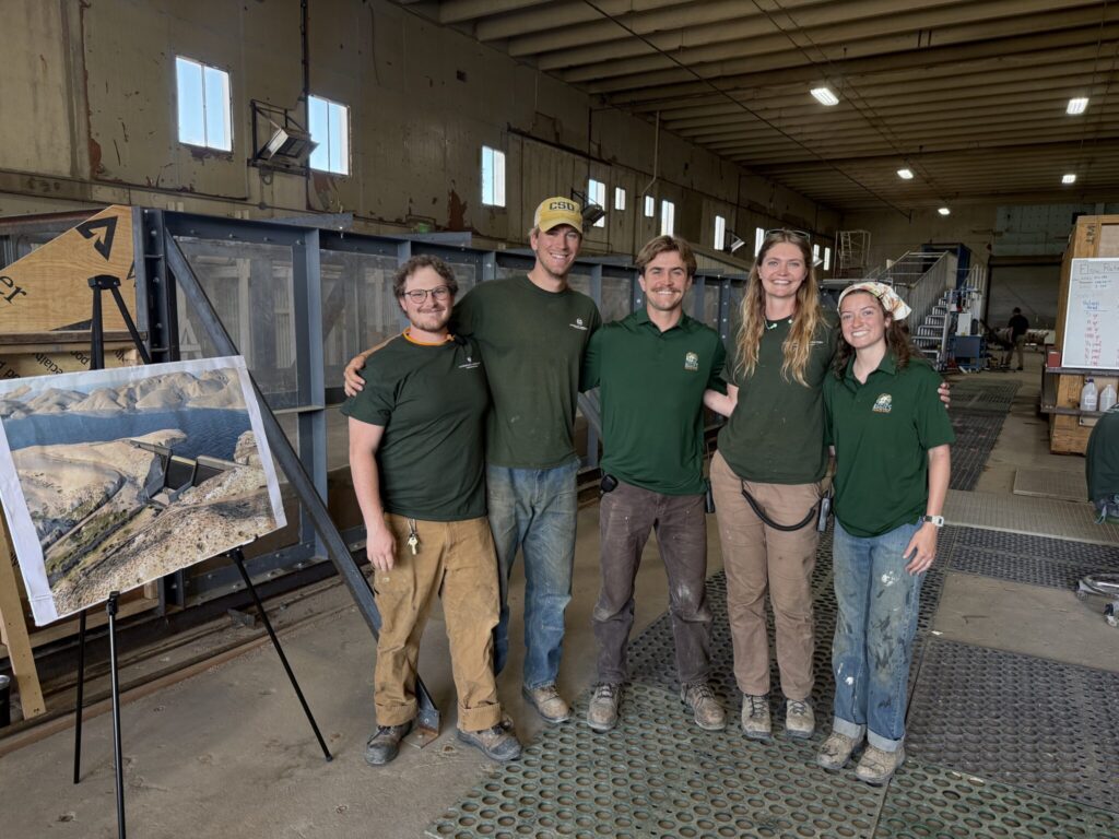 Undergraduate students working on a Halligan Dam model pose for a photo.