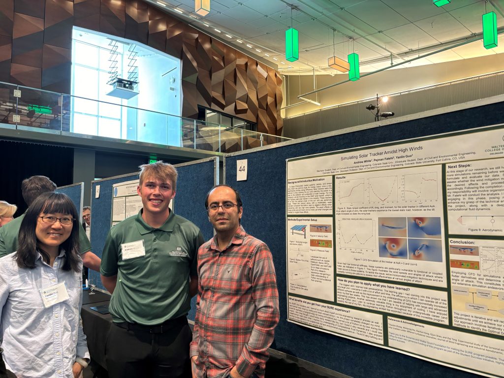 Andrew White standing with Dr. Guo and another researcher at a poster presentation.